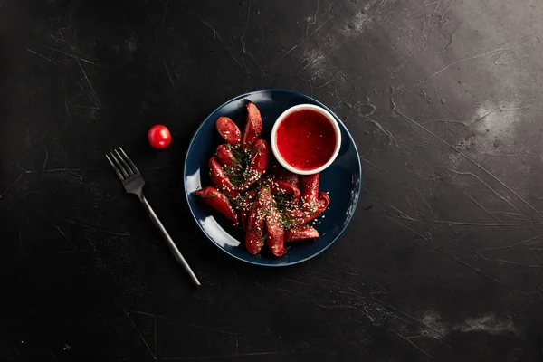 烤香肠 蔬菜放在蓝色盘子里 黑色底色 — 图库照片
