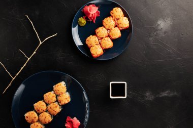 Siyah desenli arka planda, tabaklarda fırınlanmış rulo