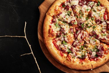 Siyah desenli arka plan görünümlü ahşap tabanlı pizza.