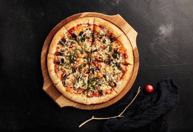 Siyah desenli arka plan görünümlü ahşap tabanlı pizza.