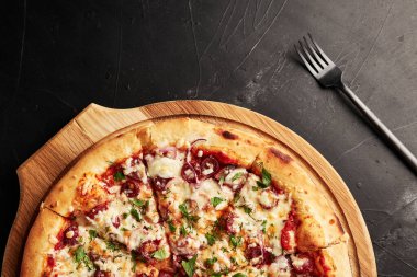 Siyah desenli arka plan görünümlü ahşap tabanlı pizza.