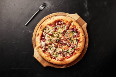 Siyah desenli arka plan görünümlü ahşap tabanlı pizza.