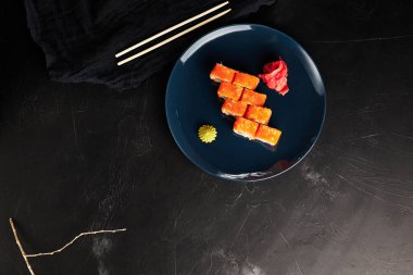 Siyah desenli arka planda mavi bir tabakta havyarda yuvarlanıyor.