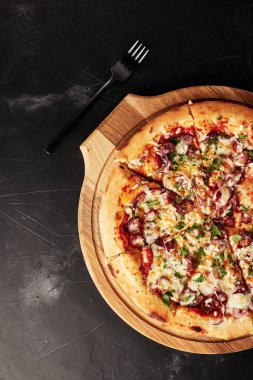 Siyah desenli arka plan görünümlü ahşap tabanlı pizza.