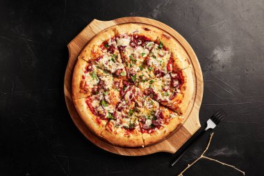 Siyah desenli arka plan görünümlü ahşap tabanlı pizza.
