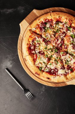 Siyah desenli arka plan görünümlü ahşap tabanlı pizza.