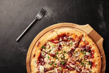 Siyah desenli arka plan görünümlü ahşap tabanlı pizza.