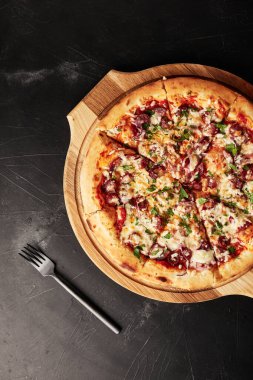 Siyah desenli arka plan görünümlü ahşap tabanlı pizza.