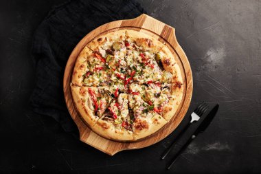 Siyah desenli arka plan görünümlü ahşap tabanlı pizza.