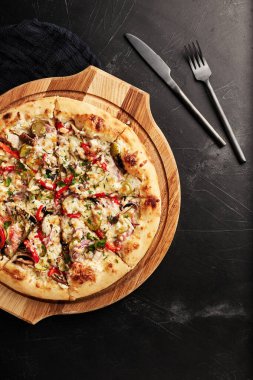 Siyah desenli arka plan görünümlü ahşap tabanlı pizza.