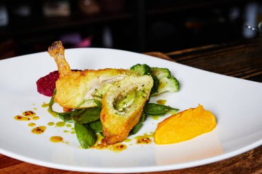 Mutfağın arka planında bir tabak Kiev pirzolası.