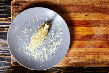 Mutfağın arka planındaki tabakta tavuk budu var.