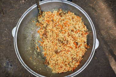 Doğada pişmiş dökme demir bir kazanda pilav.