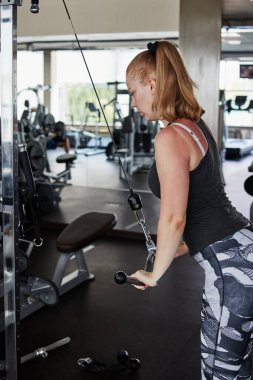 Kız spor salonunda çapraz egzersiz yapıyor.