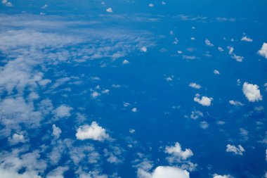 Gökyüzü ve bulutlar uçağın penceresinden yukarıdan