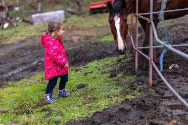 Çocuk Paltosu Giyiyor Açık havada Atla Bağlanıyor
