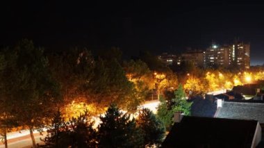 Şehirdeki Zaman Hızı Gecesi. Rush Hour 'da ana yolda yoğun trafik vardı. Bulanık araba ışıkları uzun süre açık kalacak. Ay ve Yıldızlar Gece Gökyüzünde Şehrin Üzerinde Hareket Ediyor.