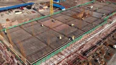 İnşaat işçilerinin inşaat halindeki bir binanın çelik çerçevesini yapmasının hava görüntüsü. İHA İnşa Alanında Yapı Etkinliği Bakış Alanı.. 