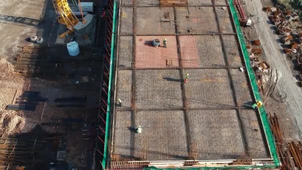 Aerial View of Construction Workers Making Steel Frame of a Building Under Construction. Drone point of view of Building Activity at Construction Site.