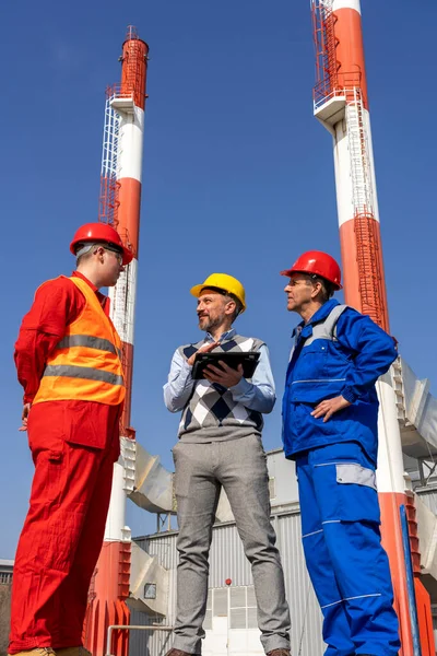 Manager Using Digital Tablet Discussing Two Workers Power Plant Chimneys — Stock Photo, Image