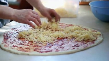 Şef, açık mutfakta pizza yapıyor. Pizza Üssüne Elleri Peynir Topları Yayılıyor. 