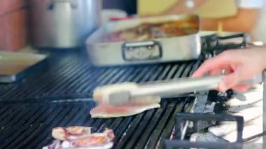 Commercial Kitchen 'da ızgarada ızgara tavuk göğsü. Izgarada ızgara ızgara et ile ızgara. Izgarada Et Döndürmek İçin Barbekü Makasları Kullanılıyor.