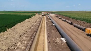 Doğal Gaz Boru Hattı Kurulumu ve İnşaat Alanı - İnsansız hava aracı bakış açısı. Borular siperin yanındaki destekleyici kum torbalarının üzerine yerleştiriliyor, kaynak eklemleri de epoksi ile kaplanıyor.. 