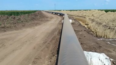 Doğal Gaz Boru Hattı İnşaat Alanının Üzerinde Uçan Alçaktan Uçan Uçak Bakış Alanı. Borular siperin yanındaki destekleyici kum torbalarının üzerine yerleştiriliyor, kaynak eklemleri de epoksi ile kaplanıyor.. 