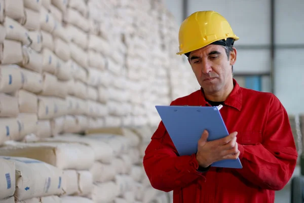 Worker Writing on Clipborad in Warehouse — Stock Photo, Image