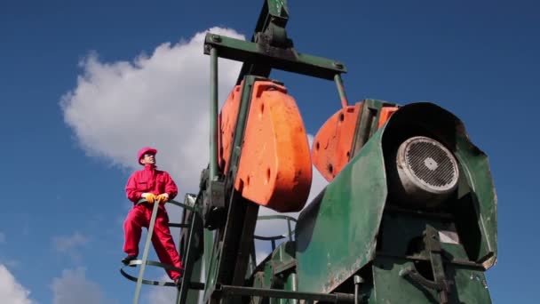 Trabajador en la bomba Jack Oil Well — Vídeos de Stock