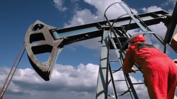 Trabajador en la bomba Jack Oil Well — Vídeos de Stock