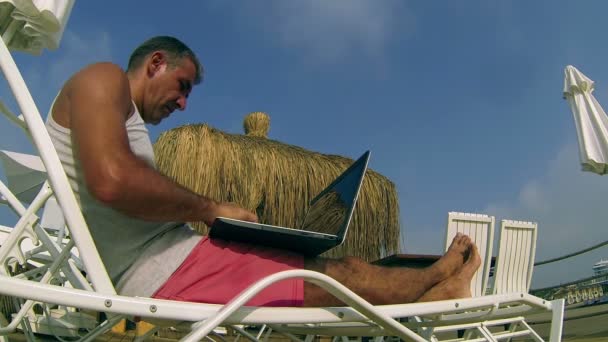 Homme avec ordinateur portable par océan — Video