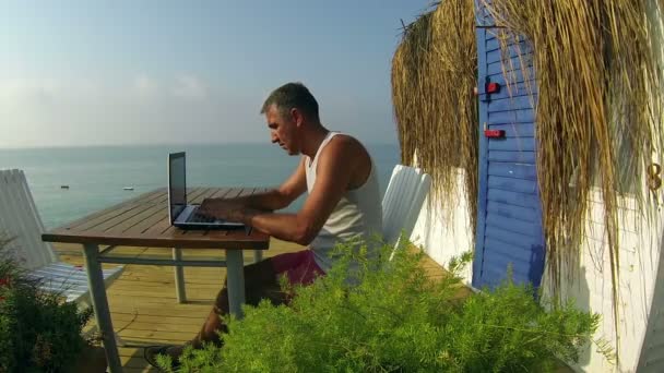 Mann mit Laptop auf See — Stockvideo