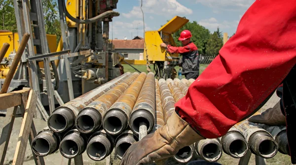 Equipamento de perfuração e dois trabalhadores do petróleo — Fotografia de Stock