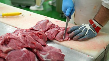 Butcher Cutting Pork Meat into Pieces for a Meat Market clipart