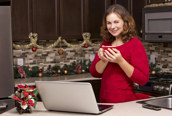 Frau mit Laptop in Weihnachtsküche — Stockfoto