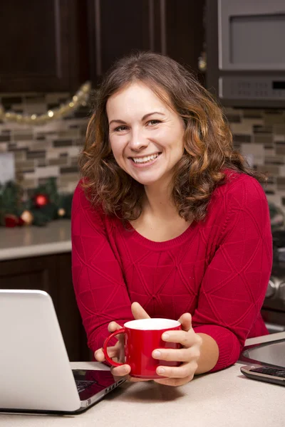 Mulher com laptop na cozinha de Natal — Fotografia de Stock