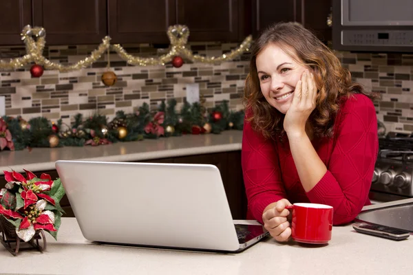 Mulher com laptop na cozinha de Natal — Fotografia de Stock