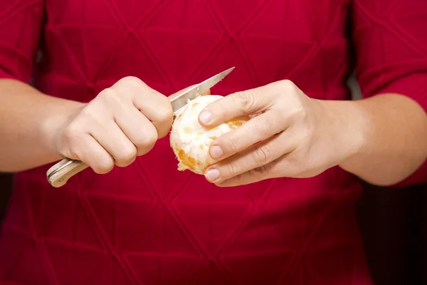 Vrouw peeling oranje — Stockfoto