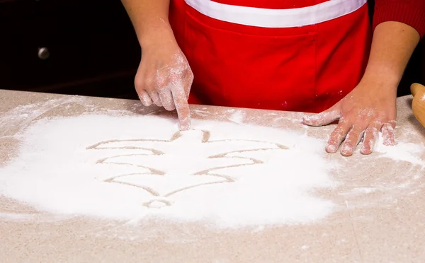 Woman drawing into flour — Stock Photo, Image