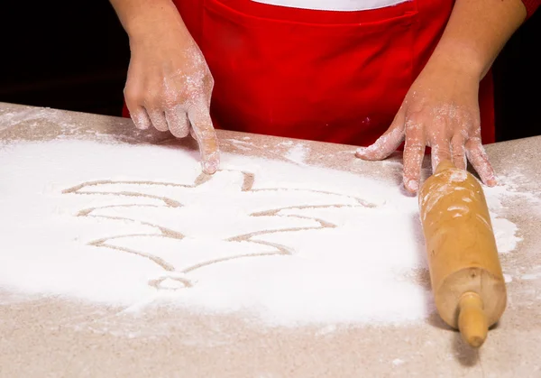 Woman drawing into flour — Stock Photo, Image