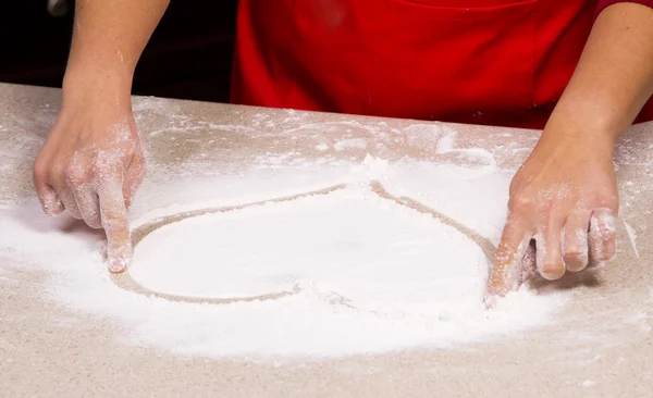 Woman drawing into flour — Stock Photo, Image