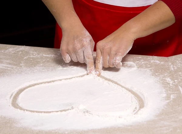 Woman drawing into flour — Stock Photo, Image