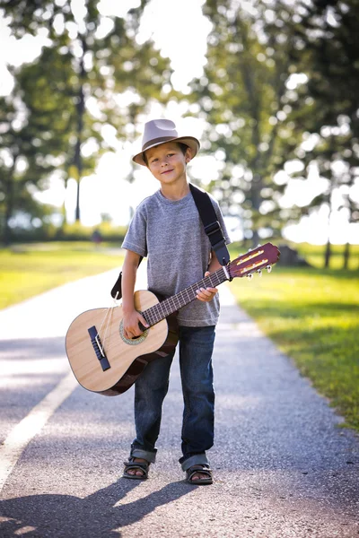 Portrait d'un petit garçon avec guitare Image En Vente