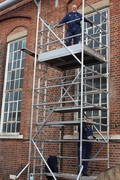 Trabajando desde una torre de andamio — Foto de Stock