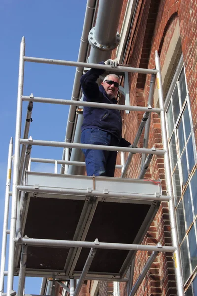 Trabajando desde una torre de andamio —  Fotos de Stock