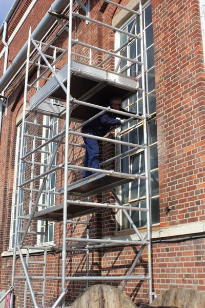 Trabajando desde una torre de andamio — Foto de Stock