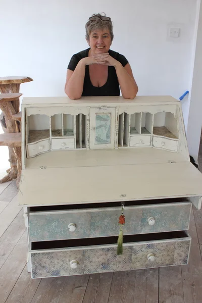 An artist painting and distressing a bureau — Stock Photo, Image