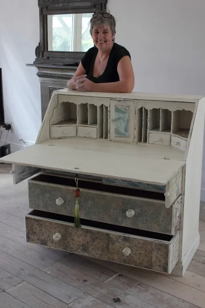 An artist painting and distressing a bureau — Stock Photo, Image
