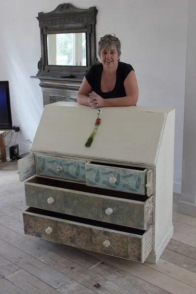 An artist painting and distressing a bureau — Stock Photo, Image